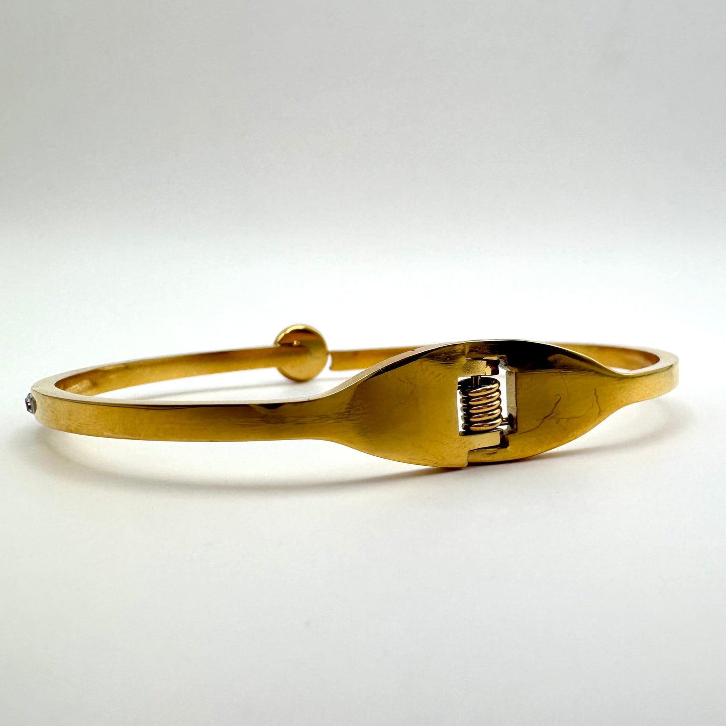 Goldfarbener Armreif mit saphirblauem Kristall und Strassbesatz